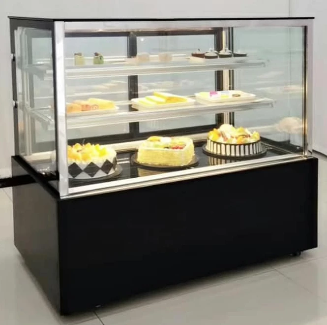 Layaan refrigerated cake display counter with a square glass front and black base panels, three lit tiers of cakes and pastries inside