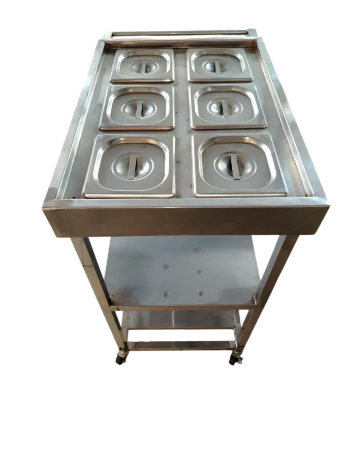 Layaan six-pan gastronorm trolley with lidded pans in a two by three top, a push rail, two solid shelves beneath and castors