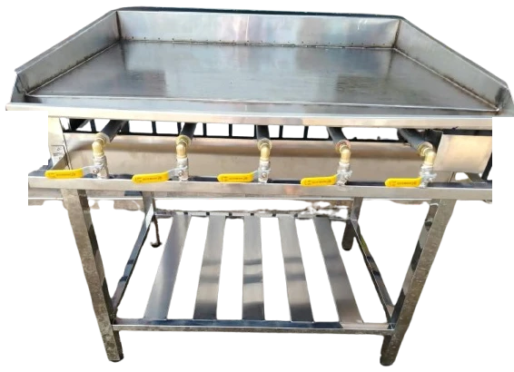 Layaan five-burner gas griddle with a flat steel plate, raised splash edges and a slatted undershelf