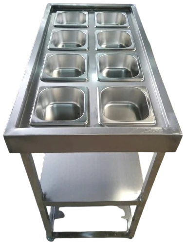 Layaan servery counter with eight stainless gastronorm pans set into a recessed top, on a stand with an undershelf