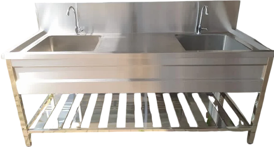 Layaan double bowl stainless steel sink run seen square on, with a pillar tap over each bowl, a drainer between them and a slatted shelf beneath